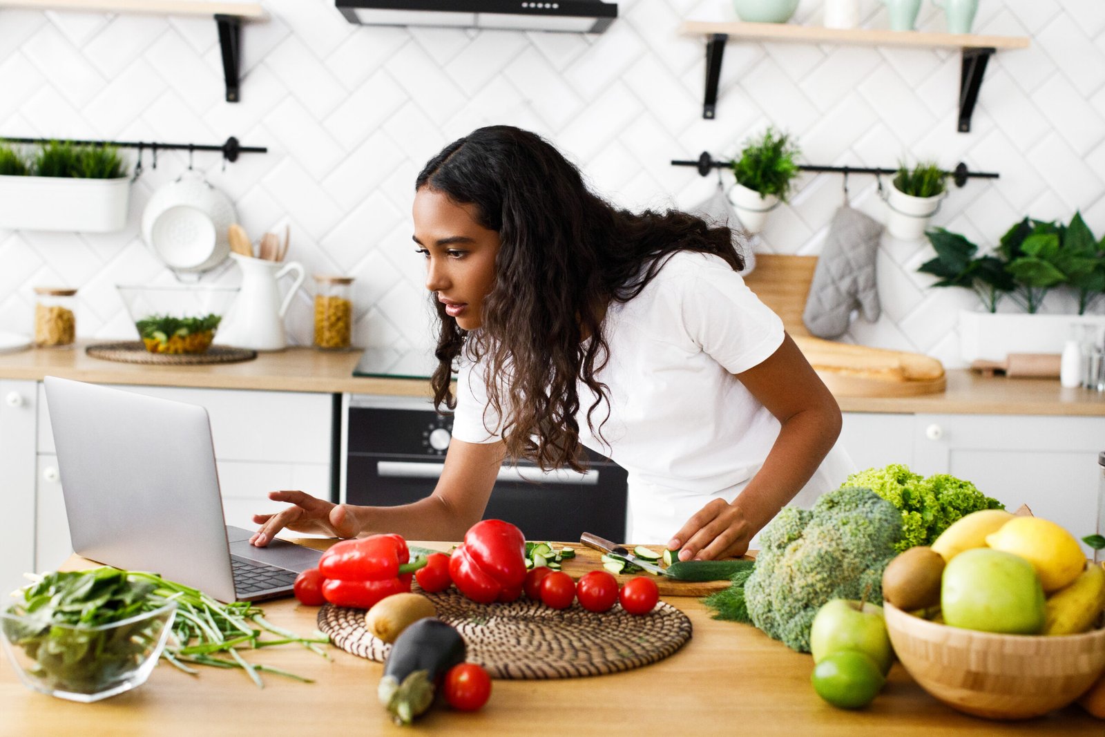 Serious pretty mulatto girl is looking on the laptop screen on